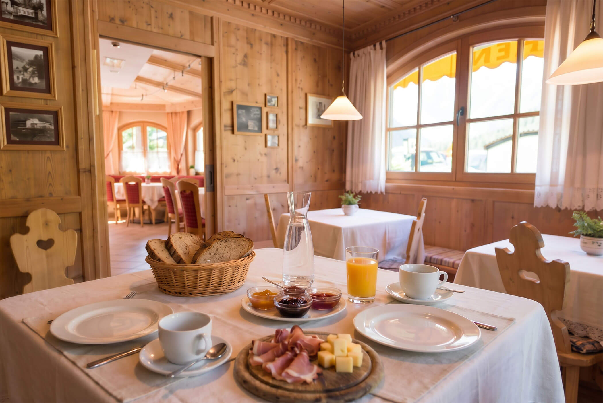 Frühstückstisch mit Brot, Aufschnitt, Käse, Marmelade, Saft und Kaffee in einem gemütlichen Holzspeisesaal. - Hotel Mooserhof