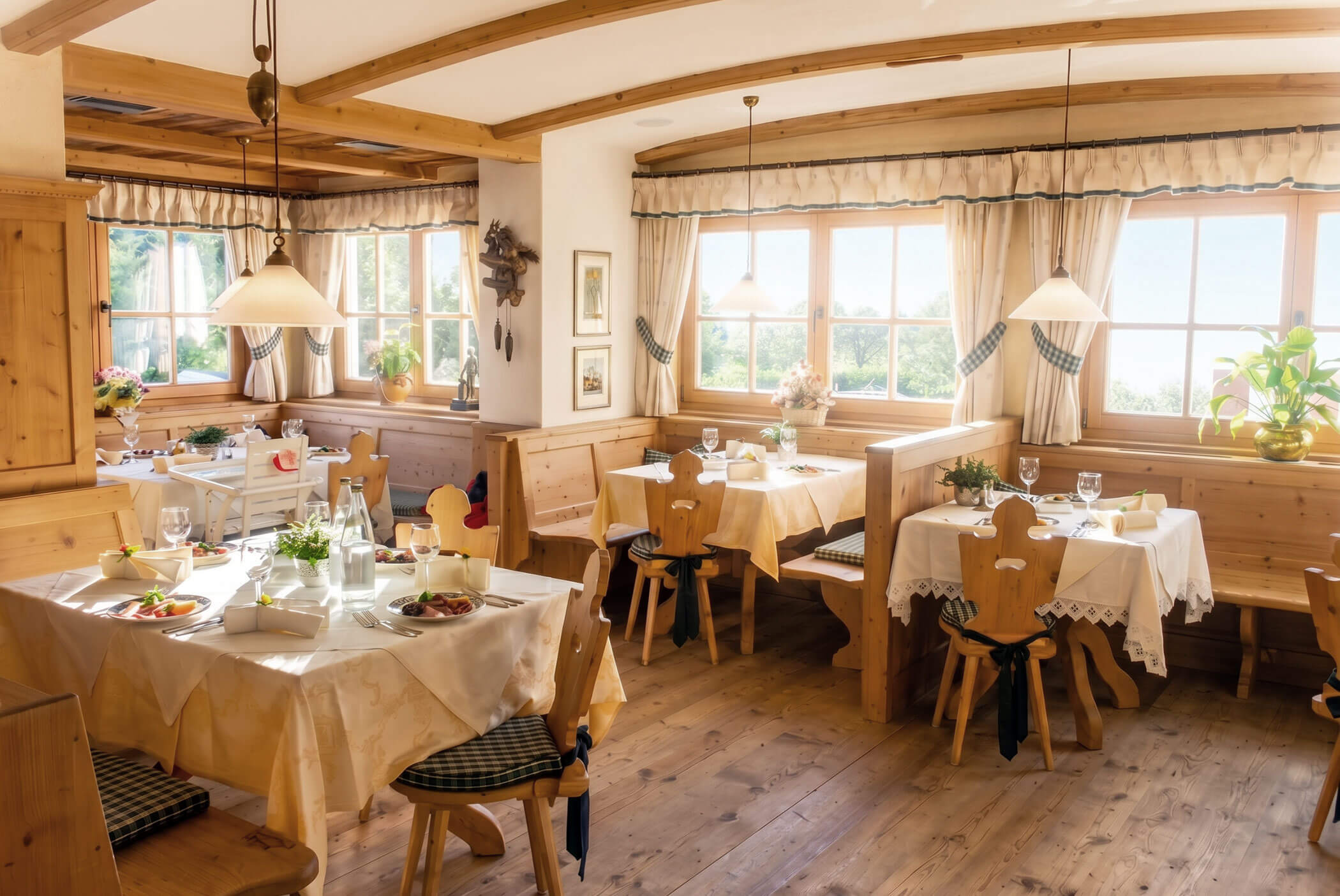Gemütliches, sonnendurchflutetes Restaurant mit Holzmöbeln, gedeckten Tischen und großen Fenstern mit Vorhängen und Pflanzen. - Hotel Mooserhof